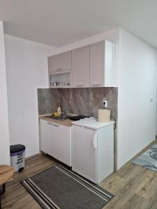 a kitchen with white cabinets and a counter top at Apartman Nena Užice 2 in Užice