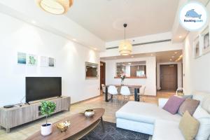een woonkamer met een bank en een tv bij Delightful Apartment - Masteri Millennium - FREE Infinity Pool in Ho Chi Minh-stad