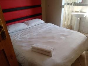 Una cama con una toalla blanca encima. en Ebony Lounge Hotel and Event Center en Pretoria