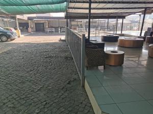 ein Gebäude mit Tischen und Stühlen auf einem Parkplatz in der Unterkunft Ebony Lounge Hotel and Event Center in Pretoria