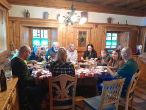 een groep mensen die rond een tafel zitten te eten bij Hirzbachgut in Fusch an der Glocknerstraße