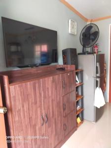 a large wooden cabinet in a kitchen with a refrigerator at Baclayon, Bohol Cozy Furnished Studio in Tagbilaran City