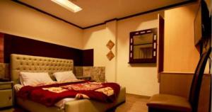 sypialnia z łóżkiem, lustrem i krzesłem w obiekcie Beverly Inn Hotel w mieście Lahaur
