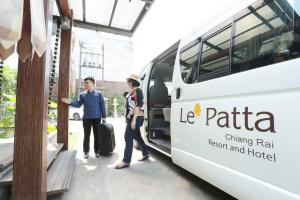 Ein Mann und eine Frau stehen neben einem Bus in der Unterkunft Le Patta Resort & Hotel Chiang Rai in Chiang Rai + 126 Fotos