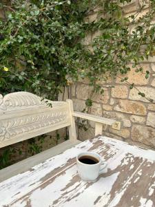 eine Tasse Kaffee auf einem Tisch neben einer Bank in der Unterkunft Selin Hotel in Alacati