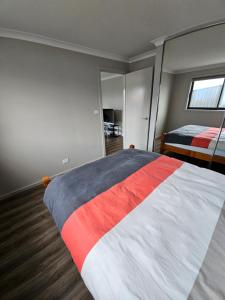 ein Schlafzimmer mit einem großen Bett und einem Spiegel in der Unterkunft Brand new self-contained one bedroom unit in Queanbeyan