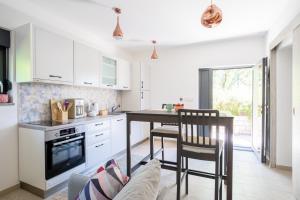 a kitchen with white cabinets and a table and chairs at Apartments Villa Rosa in Rovinj +62 photos