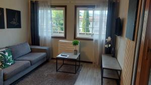 een woonkamer met een bank en een tafel bij Øren apartment in Drammen