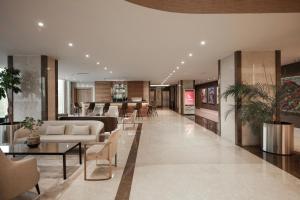 un vestíbulo con sofás y mesas y un bar en Concorde Tower Hotel & Casino, en Lefkosa Turk