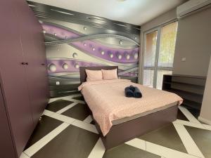 - une chambre avec un lit et un mur violet dans l'établissement Spacious apartment in the heart of Studentski grad, à Sofia