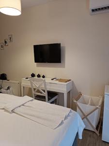 a bedroom with a desk and a tv on the wall at Limis Hotel in Çanakkale