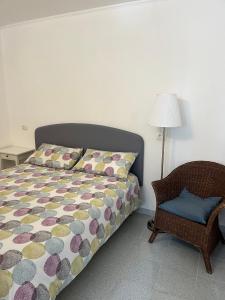 1 dormitorio con 1 cama, 1 silla y 1 lámpara en Il Glicine - Monolocale a due passi dal centro, en Urbino