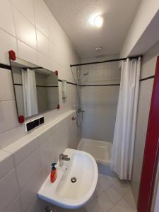 a white bathroom with a sink and a shower at Boardinghouse Steinen in Steinen