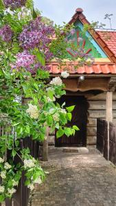 Cabaña de madera con flores púrpuras en el techo en Gniazdo w Felicjanowie, en Uniejów
