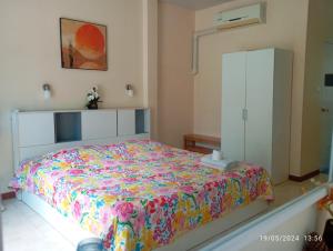 a bedroom with a bed and a white cabinet at Belinda Home in Ko Si Chang