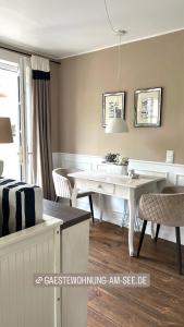 a living room with a white table and chairs at Gästewohnung am See in Neuenkirchen