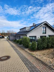 a white house with a cobblestone driveway at Apartment am Engelsblick - die Eifel direkt vor der Tür in Kreuzau