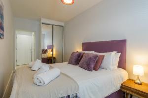a bedroom with a large bed with towels on it at 15 Woolacombe East @Byron in Woolacombe +18 photos