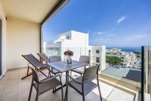 jadalnia ze stołem i krzesłami na balkonie w obiekcie Fl5 Thelodge-stunning Views With Spacious Terrace w mieście Mellieħa