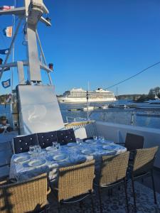 M/S Furusund في Furusund: طاولة على قارب مع سفينة سياحية في الخلفية