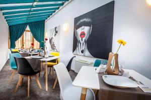 a restaurant with tables and chairs and a painting on the wall at HOTEL CIAO in Târgu-Mureş