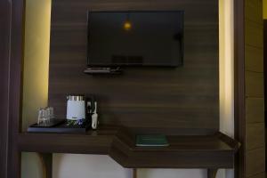 a room with a table with a tv on a wall at Whispering Winds Resort in Dharamshala