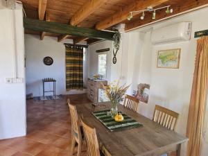 a dining room with a wooden table and chairs at Cortijo La Vista in Órgiva