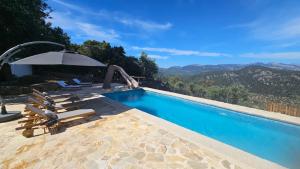 a swimming pool with lounge chairs and an umbrella at Finca Es Verger in Esporles