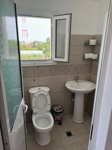 a bathroom with a toilet and a sink at Holiday House in Lezhë