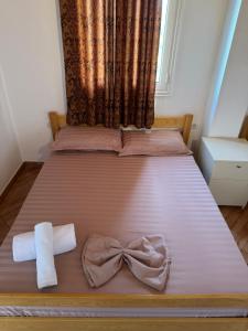 a bed with a bow and a towel on it at Holiday House in Lezhë