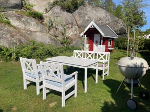 ein Tisch und zwei Stühle und ein Haus mit Grill in der Unterkunft Suite i gjestehus, nær sentrum in Sandefjord
