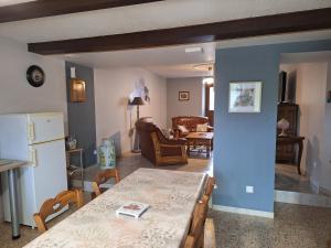 a living room with a table and a dining room at Maison De Vacances in Blondefontaine