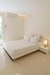a white bed in a white room with a lamp at Cannes: superbe appartement de type T2 pour 4 pers in Cannes