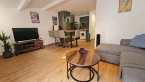 ein Wohnzimmer mit Sofa und Tisch in der Unterkunft Appartement cool en plein centre de Libourne in Libourne