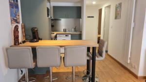 eine Küche mit einem Holztisch und 4 Stühlen in der Unterkunft Appartement cool en plein centre de Libourne in Libourne + 4 Fotos
