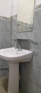 W łazience znajduje się biała umywalka i lustro. w obiekcie EESTEE Canal w Kolombo