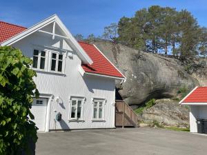 uma casa branca com um telhado vermelho em Moderne og velutstyrt leilighet nær sentrum em Sandefjord