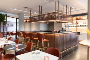 a restaurant with a bar with tables and chairs at AC Hotel Paris Porte Maillot by Marriott in Paris +56 photos