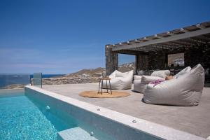 a pool with pillows and a table on the edge of a house at Cabana Seaview Pool Villas near Alemagou beach in Ftelia +26 photos