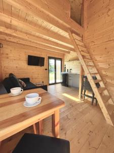 a wooden cabin with a wooden table and a dining room at Projekt Przełazy 1 in Przełazy