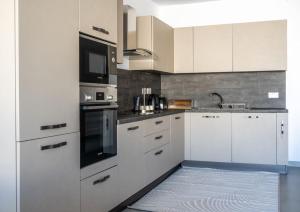 Una cocina con gabinetes blancos y un horno de estufa. en LA88 Cityway Apartment 4, en Il-Gżira