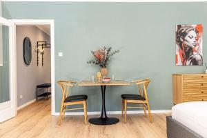 a dining room with a table and two chairs at have-a-nice-Stay - nahe Bahnhof Ahrensburg - 20 Minuten nach Hamburg - trotzdem ruhig gelegen - 6 Minuten zu Fuß ins Zentrum Ahrensburg - modern eingerichtet in Ahrensburg