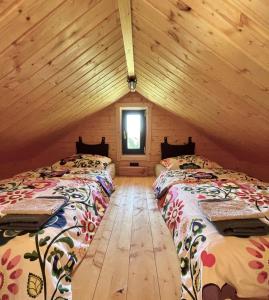 two beds in a log cabin with a window at Projekt Przełazy 1 in Przełazy