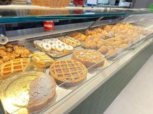 a display case with many different types of bread and pastries at La Via Del Mare in Palinuro