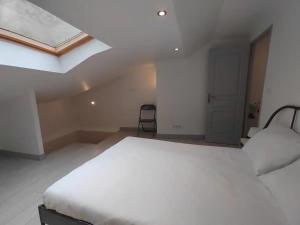 Un dormitorio con una cama blanca grande y una ventana en Le triplex de l'union, en Périgueux