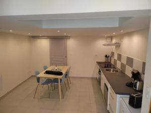 Una cocina con una mesa y sillas en una habitación. en Le triplex de l'union, en Périgueux