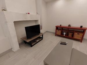 sala de estar con TV y chimenea en Le triplex de l'union, en Périgueux
