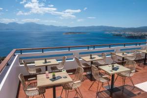 Sunlight Elounda - Adults only Hotel "by Checkin" في آغيوس نيكولاوس: مطعم على طاولات وكراسي على شرفة
