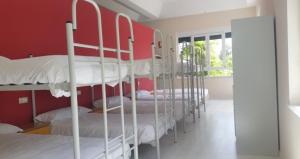a group of bunk beds in a room with red walls at Albergue de Guardo in Guardo