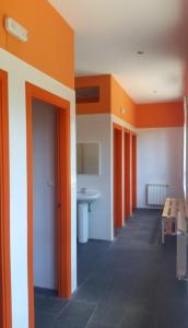 an empty room with orange walls and a table at Albergue de Guardo in Guardo